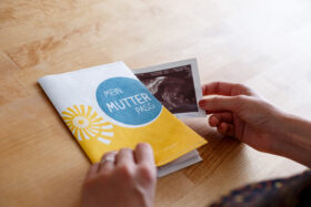Gelbe Mutterpasshülle des Netzwerkes Gesunde Kinder mit Ultraschallbild